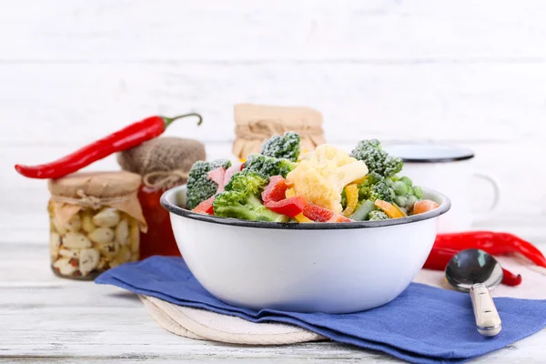 Verduras congeladas en tazón sobre servilleta, sobre fondo de mesa de madera — Foto de Stock