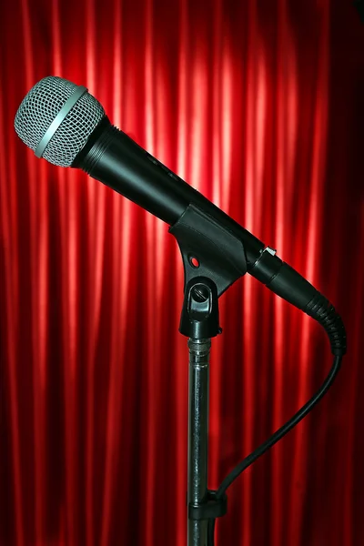 Microphone on stand on red curtain background — Stock Photo, Image