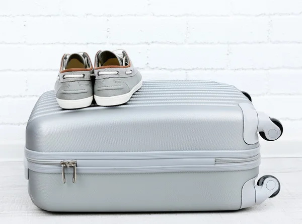 Gray suitcase with male shoes on floor on brick wall background — Stock Photo, Image