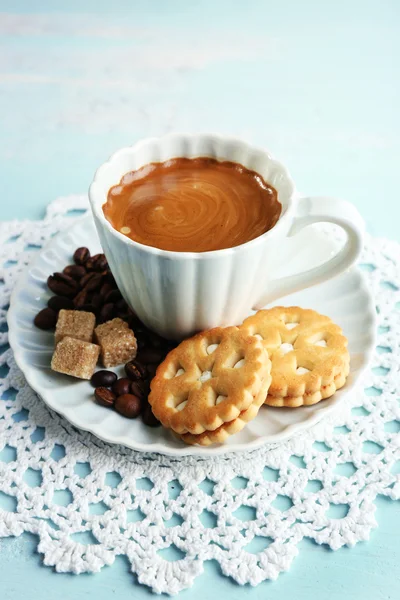 Kopp kaffe och läckra cookie på färg trä bakgrund — Stockfoto