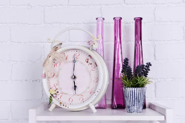 Дизайн интерьера на столе с будильником, растительными и декоративными вазами на фоне стены из белого кирпича — стоковое фото