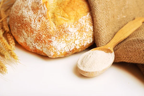 Fresh bread with wheat and wooden spoon of flour, closeup — Stock Photo, Image
