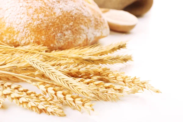 Fresh bread with wheat and wooden spoon of flour, closeup — Stock Photo, Image