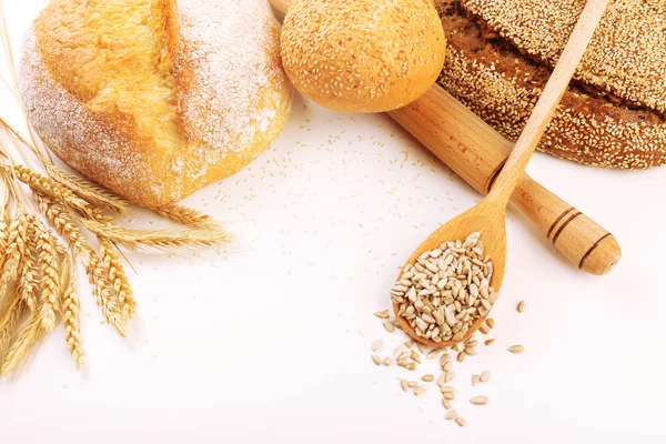 Frisches Brot mit Weizen und Holzlöffel Sonnenblumenkerne isoliert auf weiß — Stockfoto