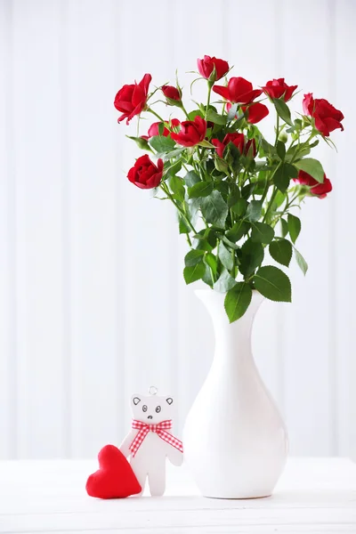 Μπουκέτο με κόκκινα τριαντάφυλλα στο βάζο σε ξύλινες σανίδες φόντο — Φωτογραφία Αρχείου