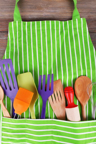 Set of kitchen utensils in pocket of apron, closeup — Stock Photo, Image