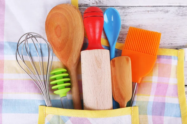 Set of kitchen utensils in pocket of apron, closeup — Stock Photo, Image