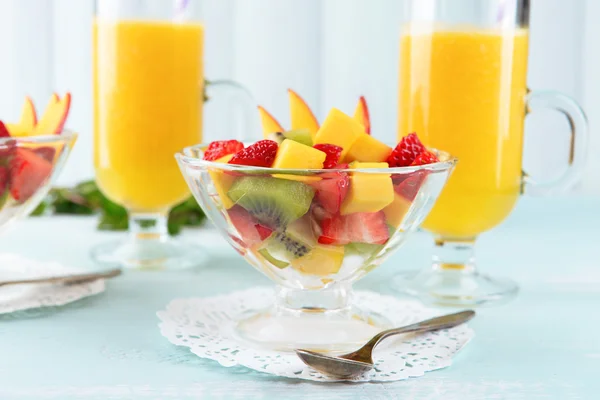 Salada de frutas com hortelã e suco de laranja em copos sobre mesa de madeira e pranchas de fundo — Fotografia de Stock