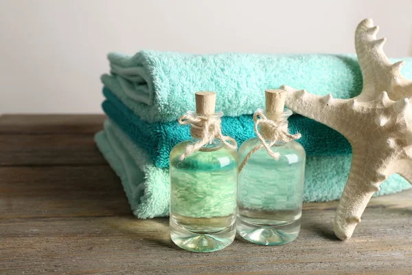 Hermosa composición con toallas y perfume sobre fondo claro —  Fotos de Stock