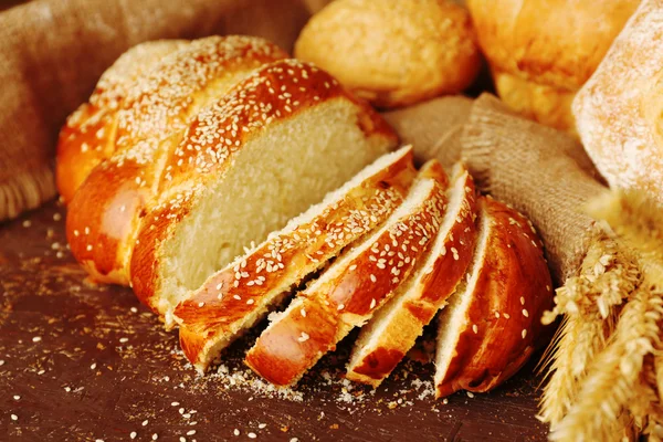 Different bread with ears on wooden background — Stock Photo, Image