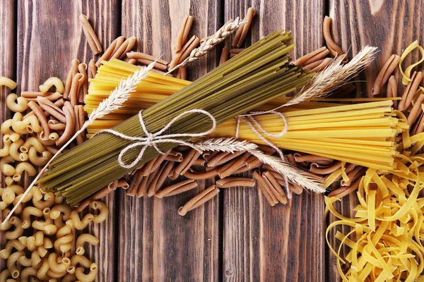 Different types of pasta on wooden background — Stock Photo, Image