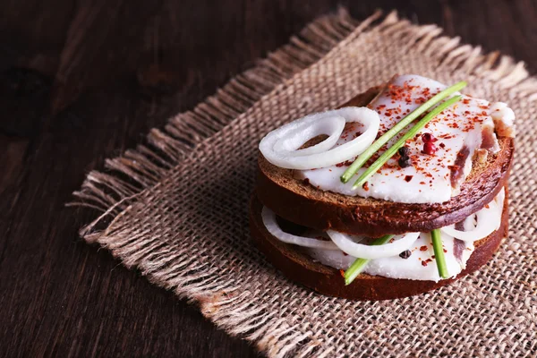 Domuz yağı ve soğan üzerinde çul masada sandviç yakın çekim — Stok fotoğraf