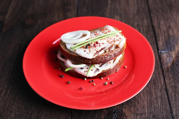 ラードと木製の背景に皿に玉ねぎのサンドイッチ — ストック写真