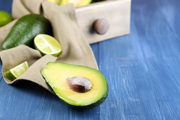 Aguacate con limas en servilleta en la mesa de cerca —  Fotos de Stock