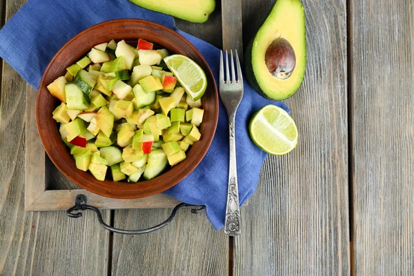 Ensalada con manzana y aguacate en tazón en bandeja sobre mesa de cerca —  Fotos de Stock