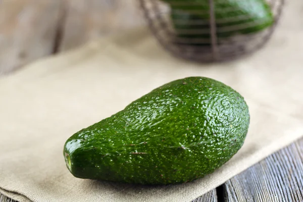 Avocado on napkin on wooden table close up — Stock Photo, Image