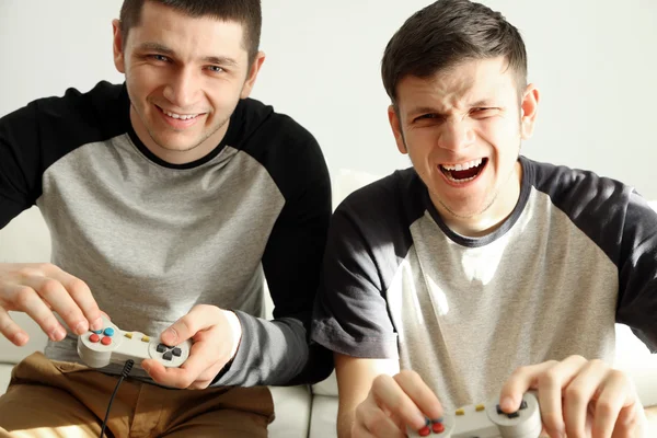 Dois jovens bonitos jogando videogames no quarto — Fotografia de Stock