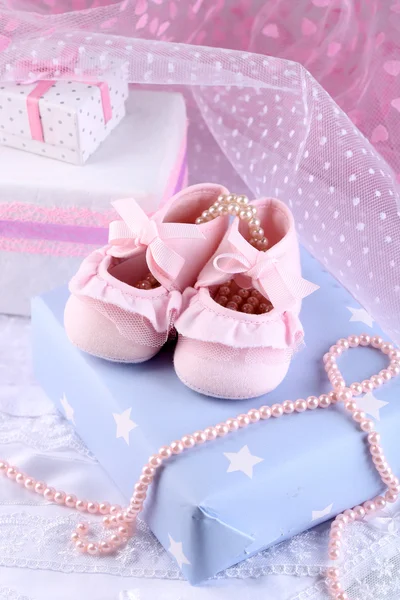 Botas de bebé rosadas con primer plano de regalo — Foto de Stock