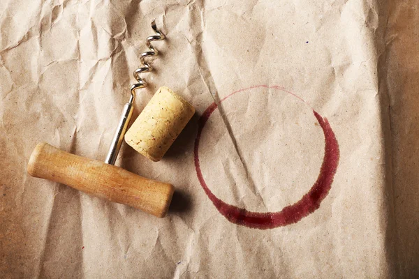 Mancha de vinho, cortiça e saca-rolhas sobre fundo de papel amassado — Fotografia de Stock