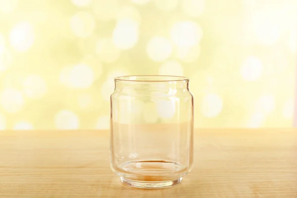 Empty glass bottle on table on bright background — Stock Photo, Image