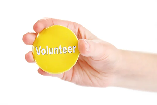 Botão de voluntário redondo na mão isolado no branco — Fotografia de Stock