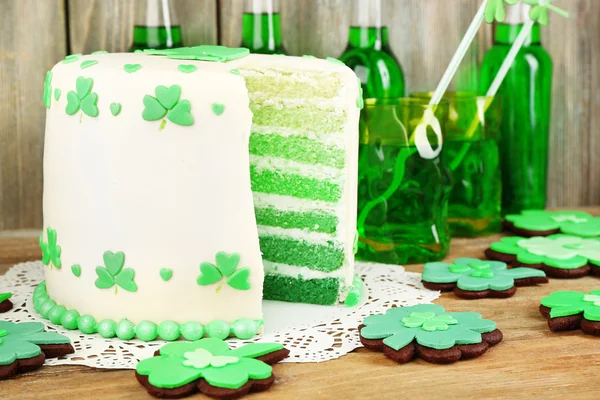 Bodegón con pastel en rodajas y cerveza verde para el Día de San Patricio sobre tabla de madera y tablones de fondo —  Fotos de Stock