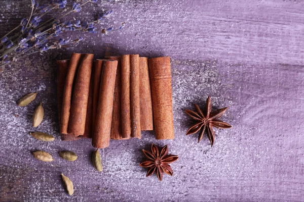 Spices with lavender and powdered sugar on color wooden table background — Stock Photo, Image