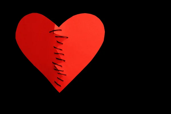 Sewed heart on black background — Stock Photo, Image