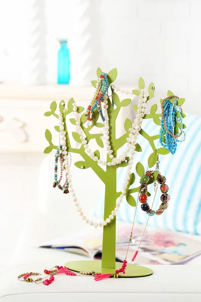 Decoratieve standaard met sieraden en bijouterie op tafel in de kamer — Stockfoto