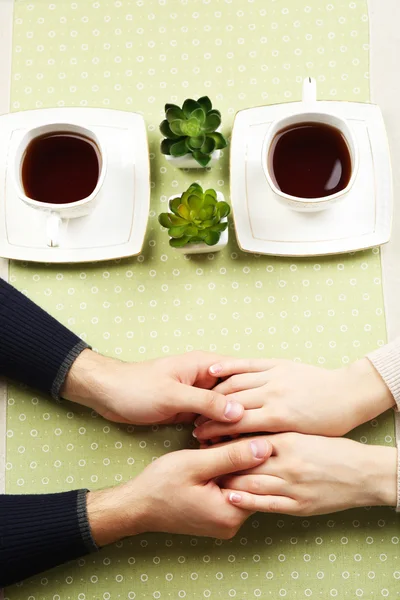 Vrouwelijke en mannelijke handen met kopjes thee, close-up — Stockfoto