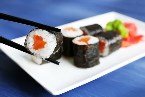 Sushi Roladki z łososia na talerzu, na tle drewniane — Zdjęcie stockowe