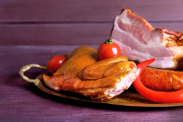 Assortimento di carne affumicata su vassoio di metallo su sfondo tavolo di legno colore — Foto Stock