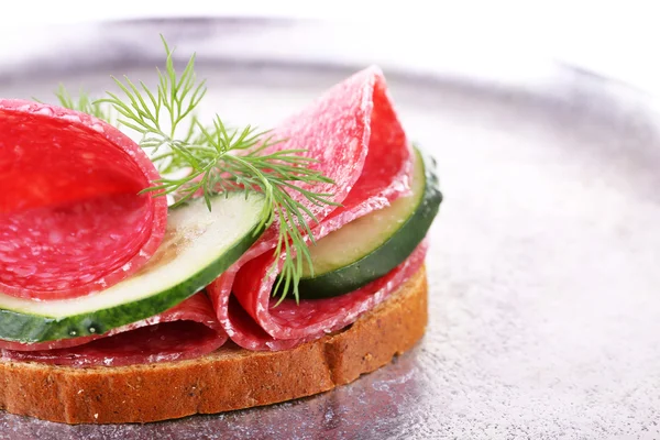 Sandwich con salami y pepino sobre fondo de bandeja metálica — Foto de Stock