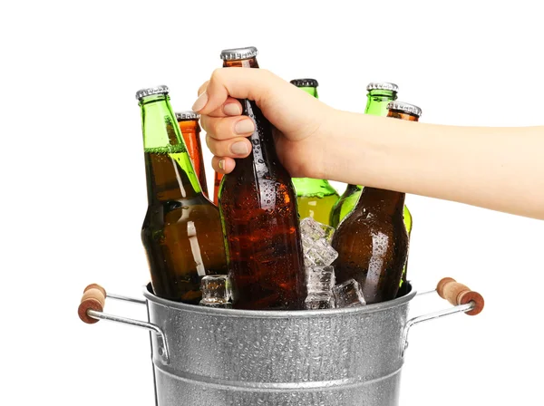 Weibliche Hand nimmt Glasflasche Bier aus Metalleimer isoliert auf weiß — Stockfoto