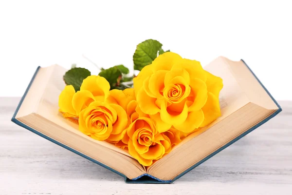 Yellow roses with open book on wooden table isolated on white — Stock Photo, Image