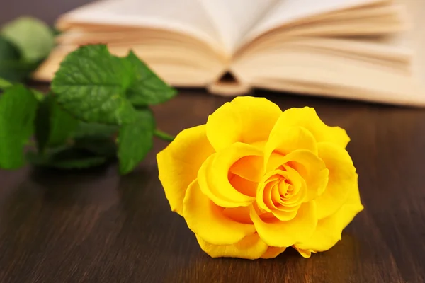Buch mit gelber Rose auf Holztischhintergrund — Stockfoto