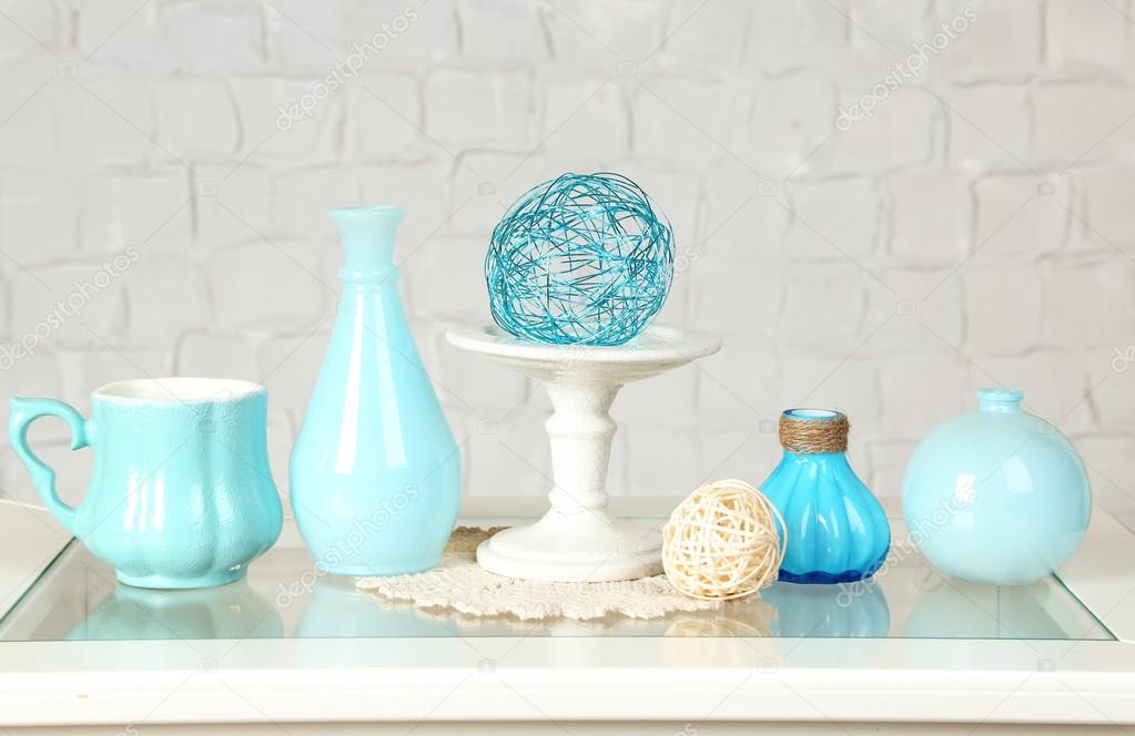 Interior with decorative vases on table top and white brick wall background