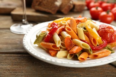 Biber, havuç ve domates ahşap masa arka plan ile makarna salatası
