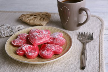 Peçete ve renk ahşap plakalar arka plan üzerinde kahve ile plaka üzerinde kalp şeklinde kurabiye