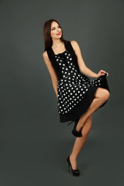 Koyu gri arka plan üzerinde nokta içinde güzel genç kadın