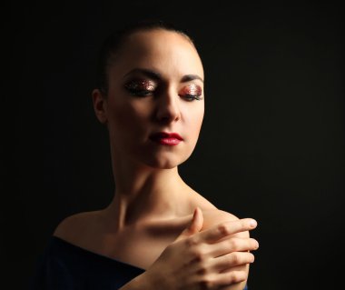 Koyu arka plan üzerinde süslü glitter makyaj ile güzel bir kadın portresi