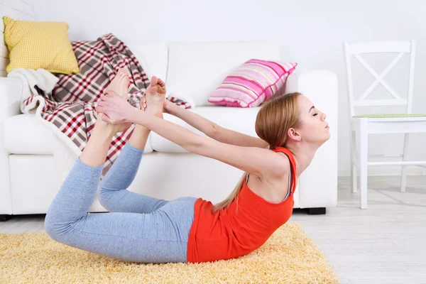 Jeune femme faisant du yoga à la maison — Photo