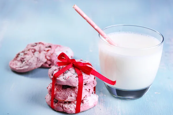 Biscoitos cor-de-rosa e copo de leite na mesa close-up — Fotografia de Stock