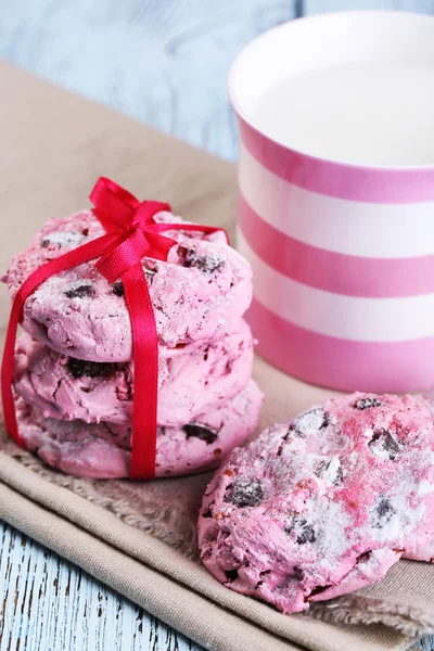 Pink cookies and cup with milk on table close-up — Stock Photo, Image