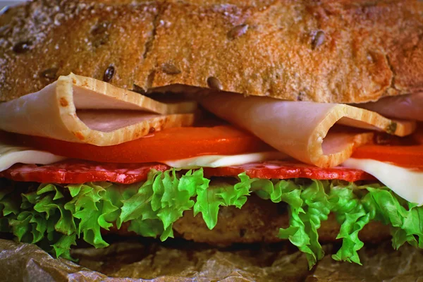 Färsk och välsmakande smörgås med skinka och grönsaker på nära håll — Stockfoto