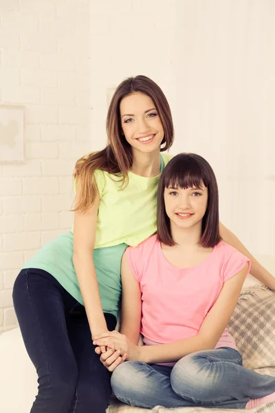 Two girls smiling on home interior background — Stock Photo, Image