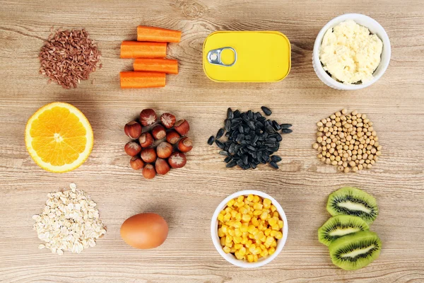 Различные пищевые продукты, содержащие витамины на деревянном фоне — стоковое фото