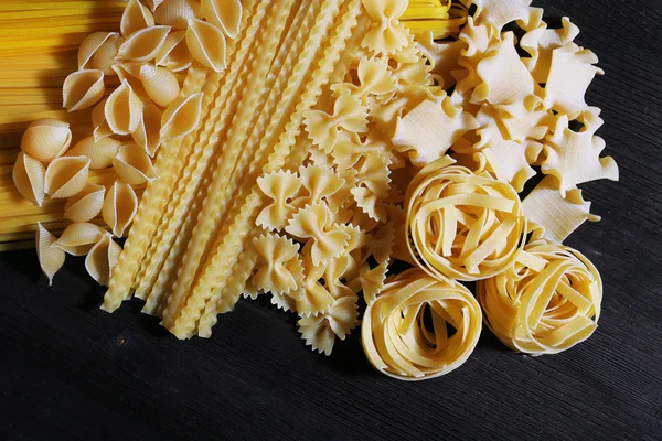 Different types of pasta on wooden table background — Stock Photo, Image