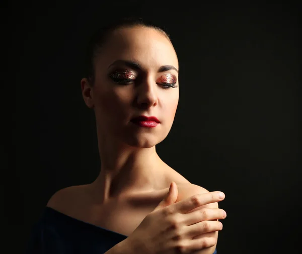 Portret van mooie vrouw met decoratieve glitter make-up op donkere achtergrond — Stockfoto