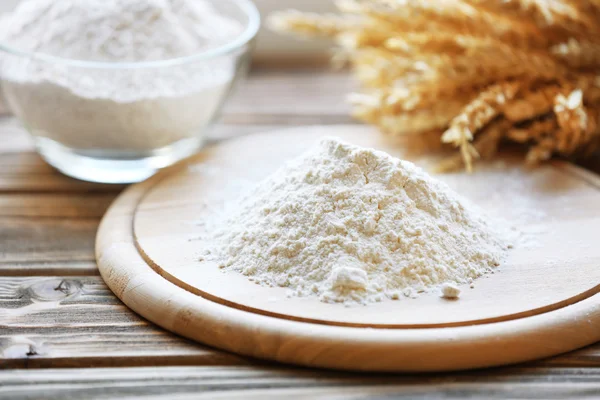 Pile of flour on cutting board with glass bowl, closeup — Stock Photo, Image